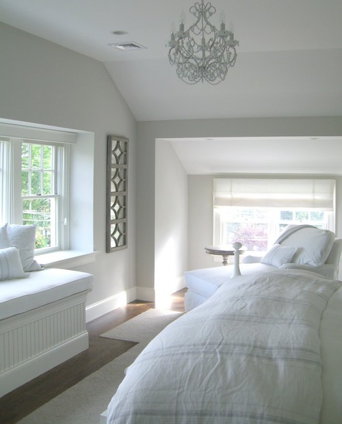bedroom with dormer window and small white chandelier painted in light pewter