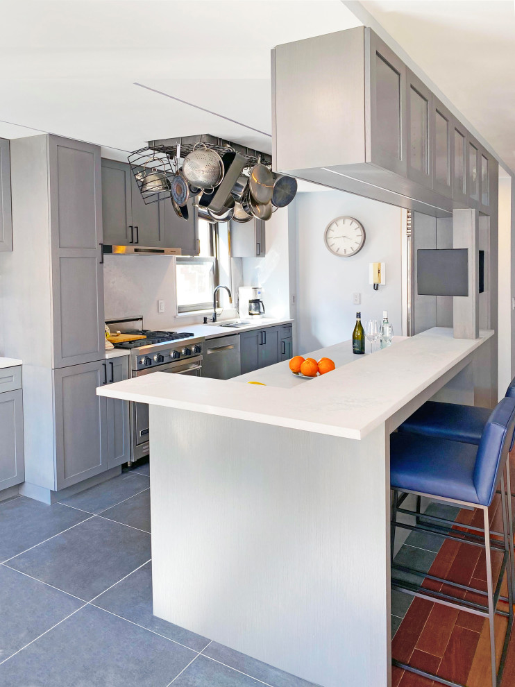 Mid-sized modern galley kitchen pantry in New York with a drop-in sink, glass-front cabinets, grey cabinets, quartzite benchtops, white splashback, stone tile splashback, stainless steel appliances, ceramic floors, with island, grey floor and white benchtop.