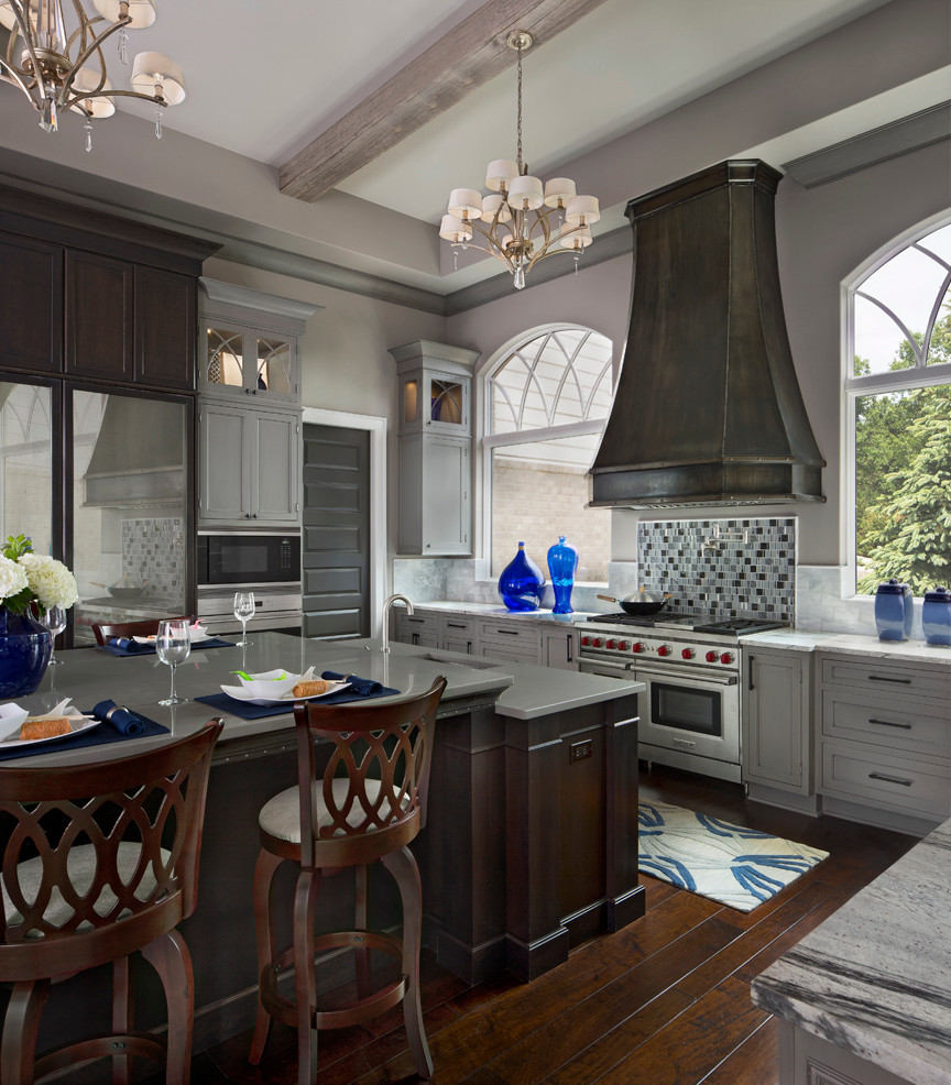 Inspiration for a huge transitional u-shaped dark wood floor open concept kitchen remodel with a farmhouse sink, recessed-panel cabinets, gray cabinets, granite countertops, multicolored backsplash, glass tile backsplash, stainless steel appliances and an island