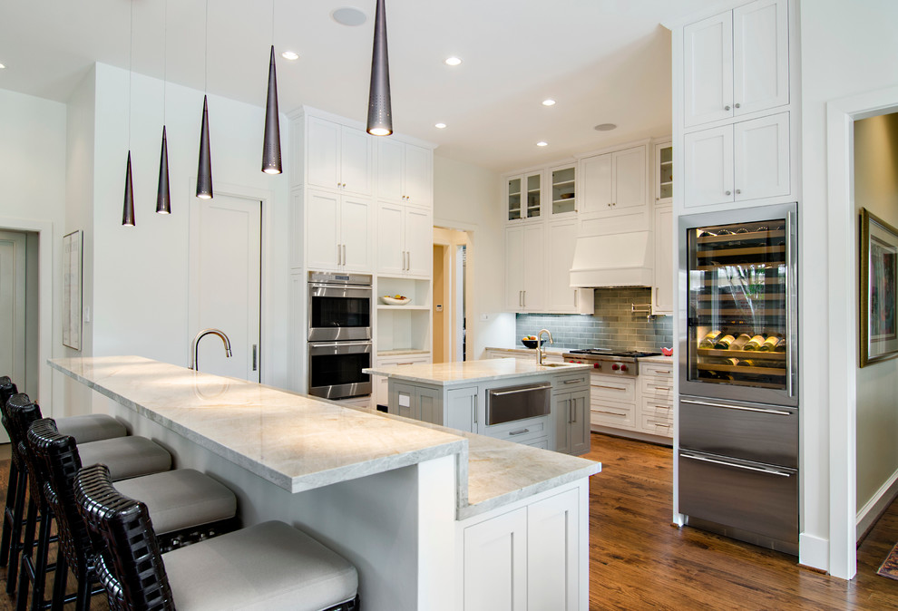 Transitional u-shaped eat-in kitchen in Dallas with an undermount sink, shaker cabinets, white cabinets, quartzite benchtops, porcelain splashback and stainless steel appliances.