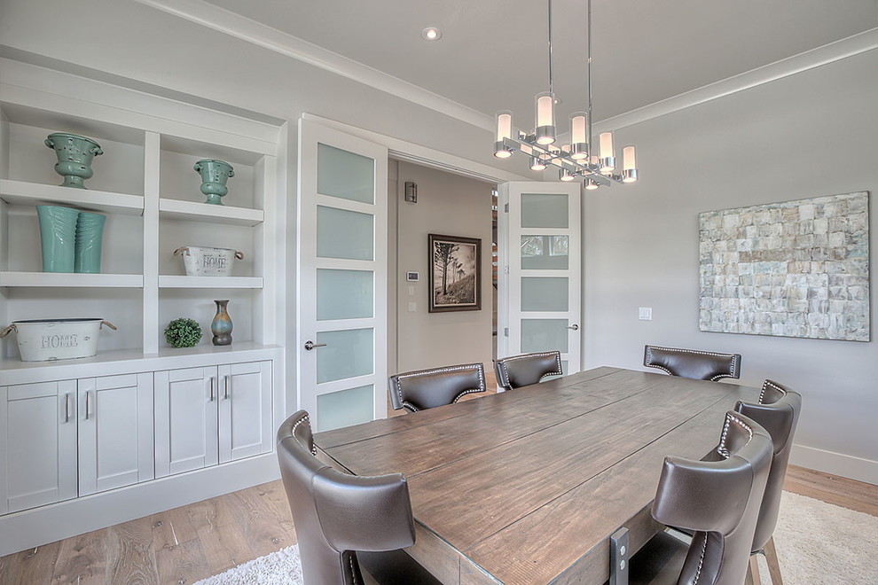 This is an example of a large contemporary separate dining room in Calgary with grey walls, medium hardwood floors, no fireplace and brown floor.