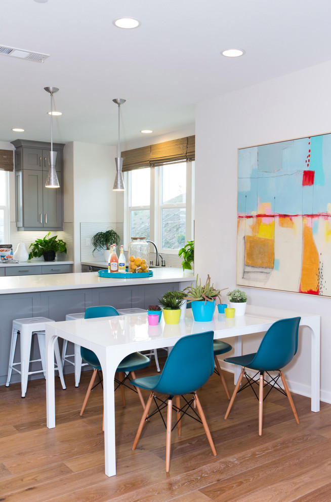 Photo of a contemporary kitchen/dining combo in Orange County with white walls and dark hardwood floors.