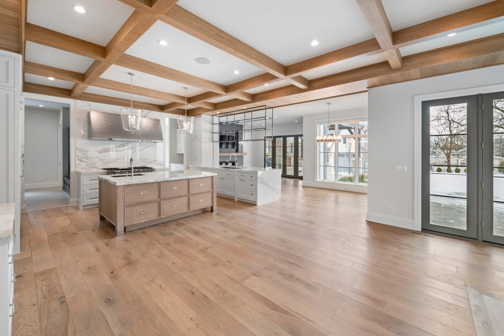Inspiration for a huge transitional u-shaped light wood floor and beige floor eat-in kitchen remodel in Chicago with an undermount sink, flat-panel cabinets, white cabinets, quartz countertops, white backsplash, stone slab backsplash, paneled appliances, an island and white countertops