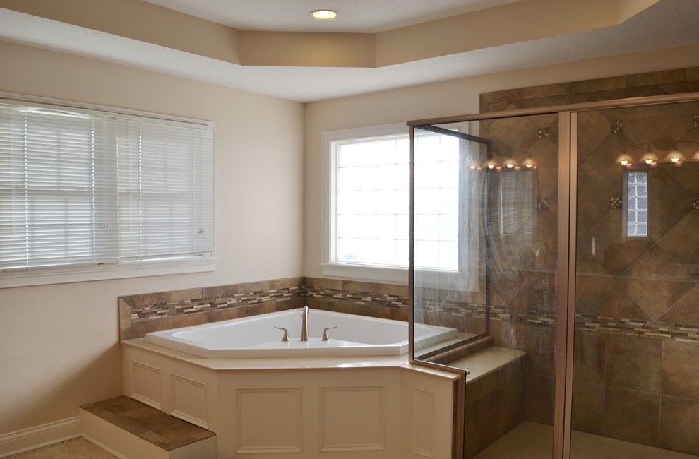 Traditional bathroom in Indianapolis with a corner tub, brown tile and matchstick tile.