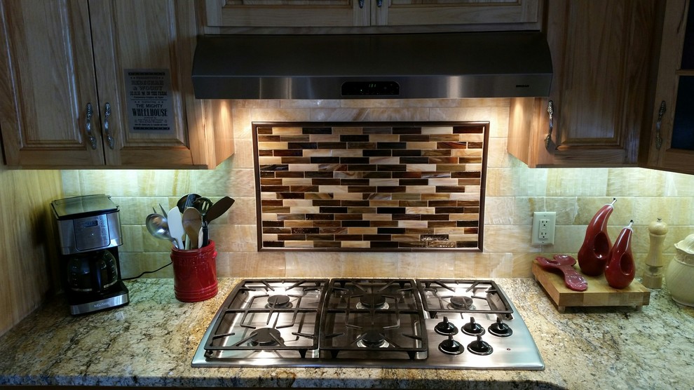 Example of a mid-sized l-shaped kitchen design with yellow backsplash, stone tile backsplash, stainless steel appliances and an island