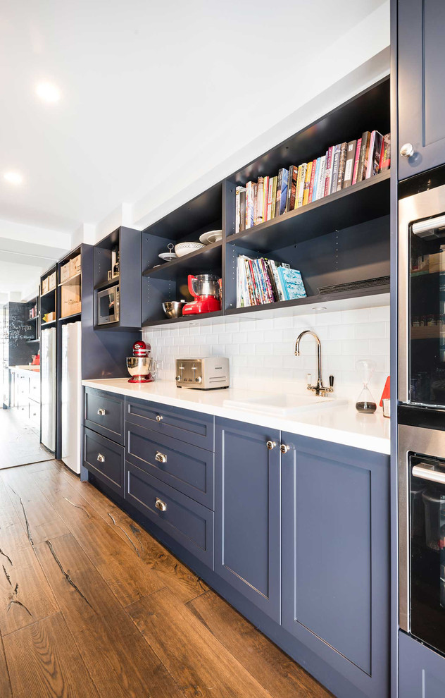 Inspiration for a large traditional u-shaped open plan kitchen in Melbourne with an undermount sink, recessed-panel cabinets, blue cabinets, marble benchtops, white splashback, ceramic splashback, stainless steel appliances, dark hardwood floors and with island.