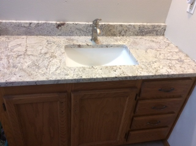 Photo of a small 3/4 bathroom in Other with recessed-panel cabinets, brown cabinets, beige walls, linoleum floors, an undermount sink and granite benchtops.