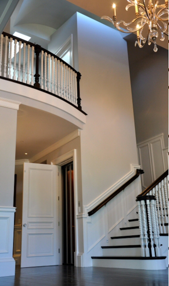 Foyer - large traditional dark wood floor and brown floor foyer idea with beige walls and a white front door