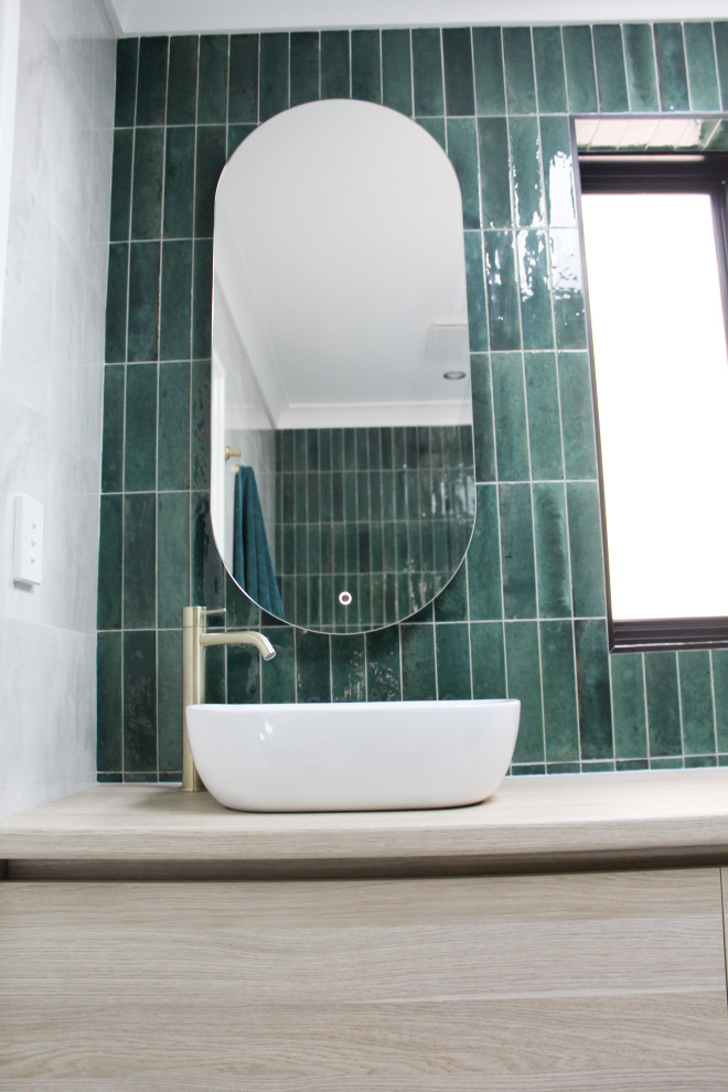 Modern inredning av ett litet beige beige en-suite badrum, med släta luckor, skåp i ljust trä, en öppen dusch, en toalettstol med hel cisternkåpa, grön kakel, stickkakel, grå väggar, klinkergolv i porslin, ett fristående handfat, träbänkskiva, vitt golv och med dusch som är öppen