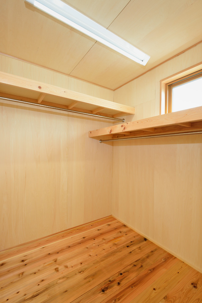 This is an example of a small asian walk-in wardrobe in Other with light hardwood floors.