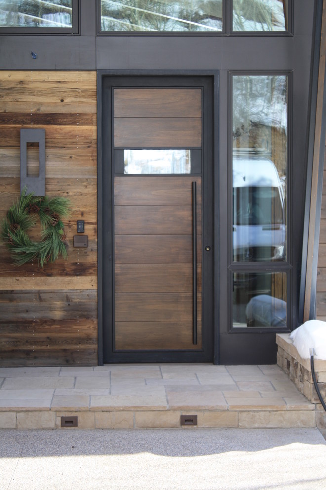 This is an example of a small modern front door in Denver with a single front door, a dark wood front door and brown walls.