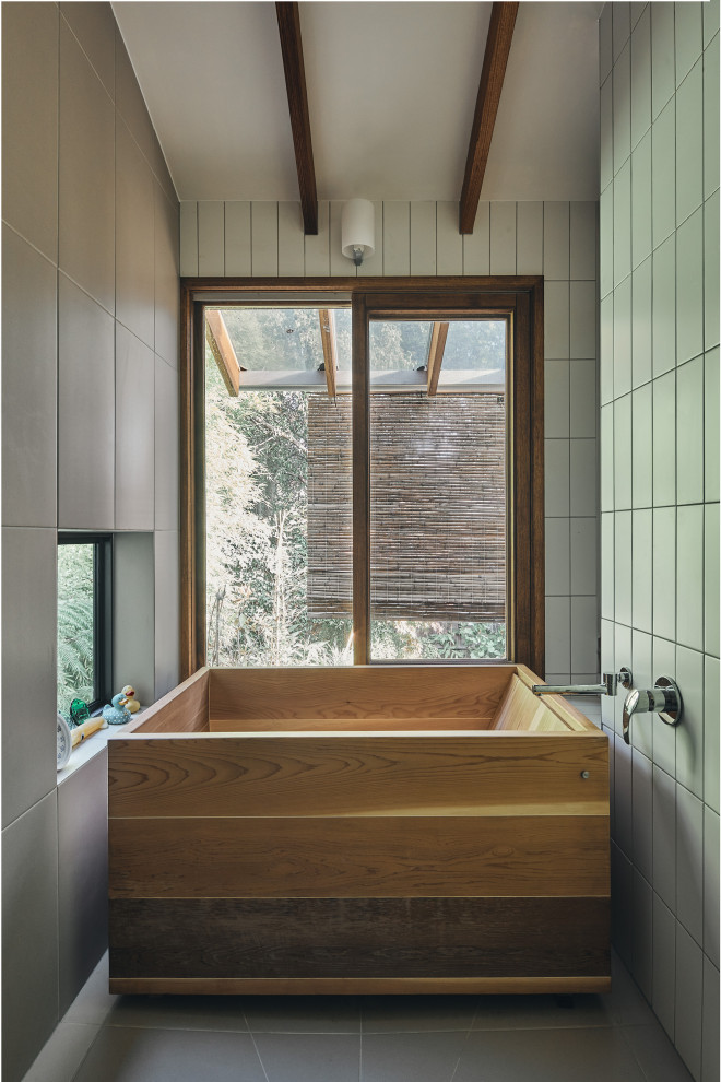 Diseño de cuarto de baño de estilo zen con puertas de armario de madera oscura, bañera japonesa, encimera de madera y vigas vistas