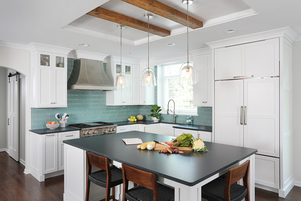 This is an example of a large eclectic l-shaped open plan kitchen in Chicago with a farmhouse sink, raised-panel cabinets, white cabinets, quartz benchtops, blue splashback, glass tile splashback, stainless steel appliances, medium hardwood floors, with island, brown floor and white benchtop.