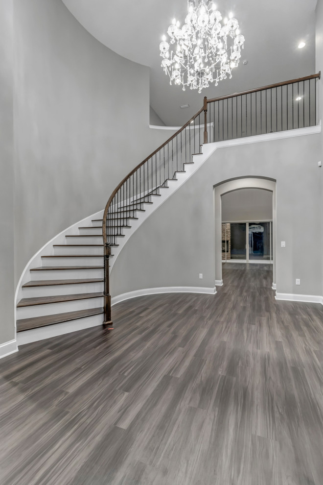 This is an example of a large mediterranean foyer in Jacksonville with grey walls, vinyl floors, a single front door, a black front door and brown floor.
