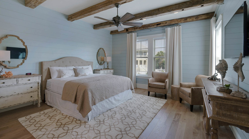 Design ideas for a large beach style master bedroom in Miami with blue walls and light hardwood floors.
