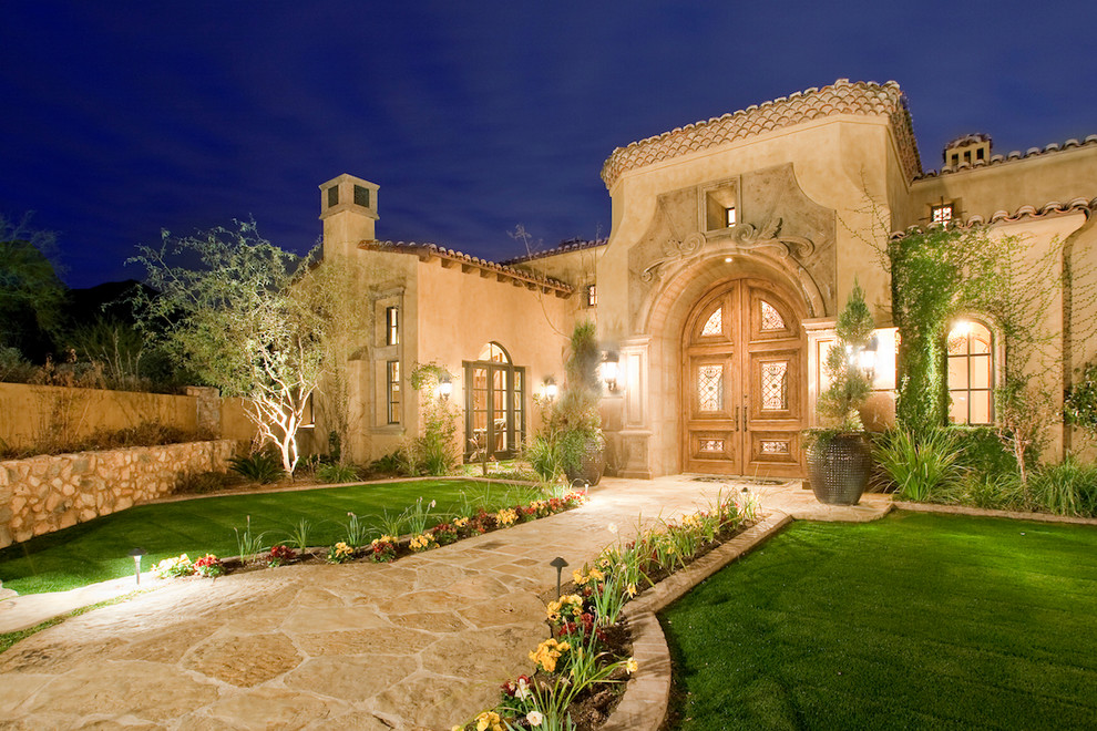 Photo of an expansive mediterranean two-storey stucco beige exterior in Phoenix with a gable roof.