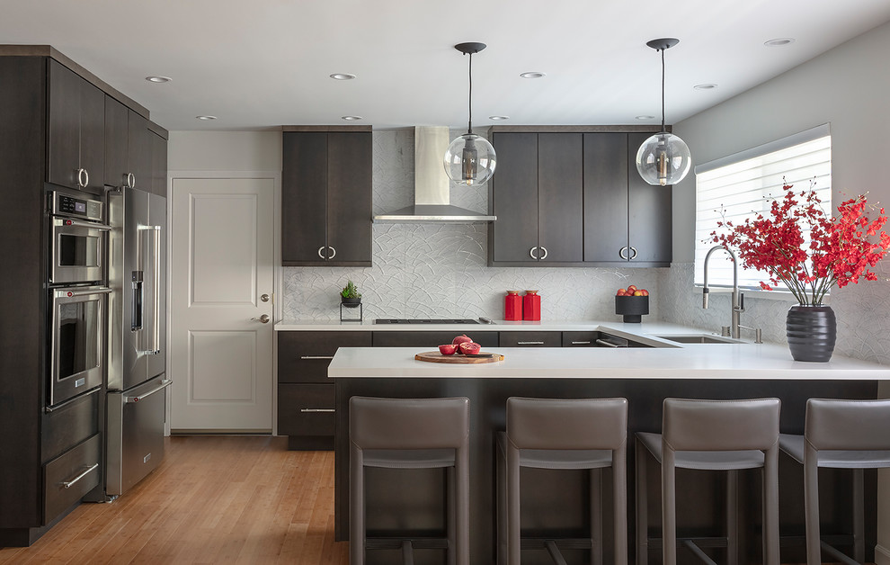 Inspiration for a contemporary u-shaped eat-in kitchen in San Francisco with a single-bowl sink, flat-panel cabinets, black cabinets, quartz benchtops, marble splashback, stainless steel appliances, bamboo floors and white benchtop.