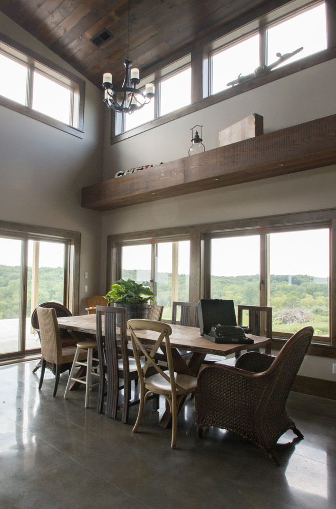 Photo of a country dining room in Cedar Rapids with beige walls and concrete floors.