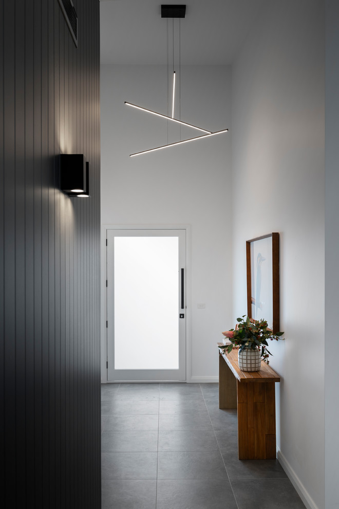 Inspiration for a mid-sized modern front door in Canberra - Queanbeyan with yellow walls, porcelain floors, a single front door, a glass front door and grey floor.