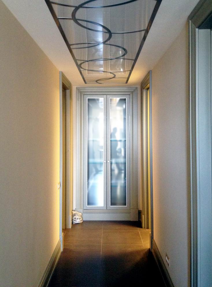 На фото: коридор среднего размера: освещение в современном стиле с серыми стенами, полом из керамогранита и коричневым полом с