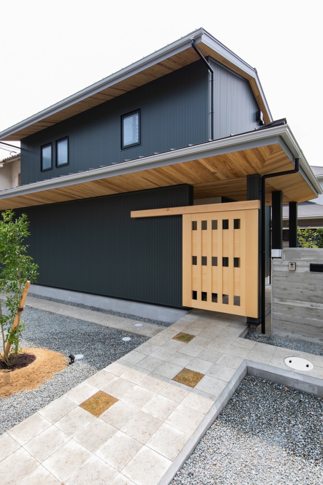 Diseño de fachada de casa verde y negra asiática de dos plantas con revestimiento de metal, tejado a dos aguas, tejado de metal y panel y listón