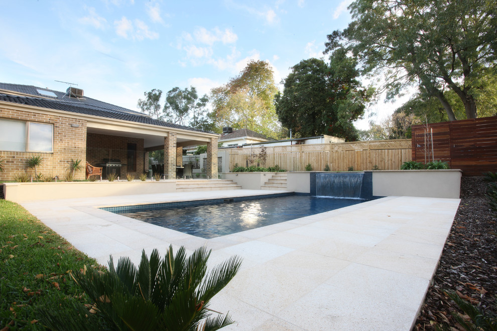 Inspiration for a large beach style backyard rectangular pool in Gold Coast - Tweed with a water feature and natural stone pavers.