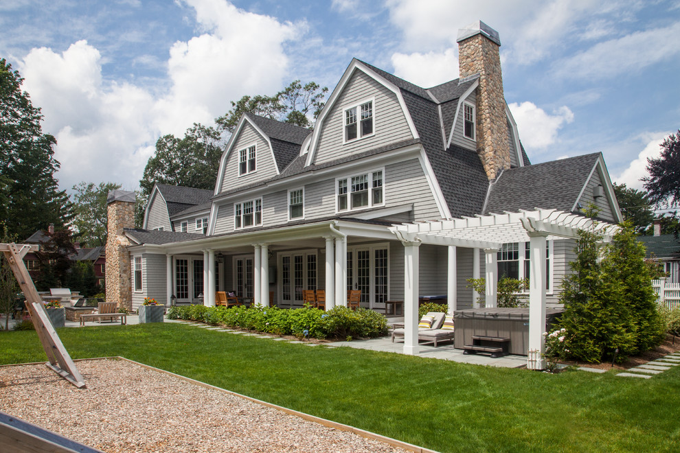 Large traditional three-storey grey house exterior in Boston with wood siding, a gambrel roof and a shingle roof.