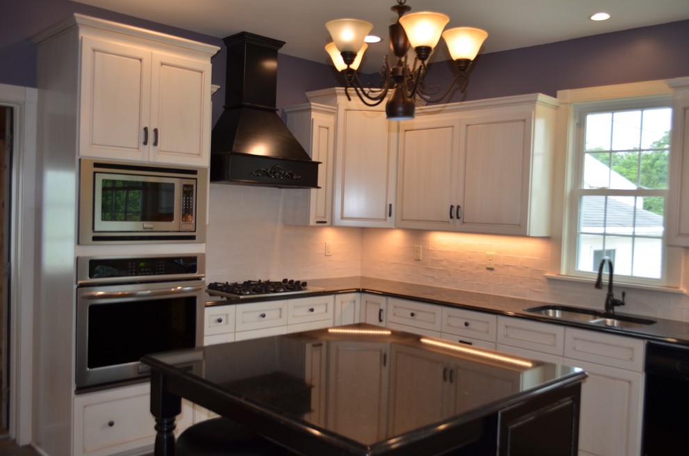 Eat-in kitchen - mid-sized transitional u-shaped brown floor eat-in kitchen idea with a double-bowl sink, recessed-panel cabinets, light wood cabinets, solid surface countertops, white backsplash, stone tile backsplash, stainless steel appliances and an island