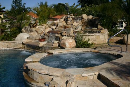 Example of a mid-sized mountain style backyard stone and custom-shaped aboveground pool fountain design in Los Angeles