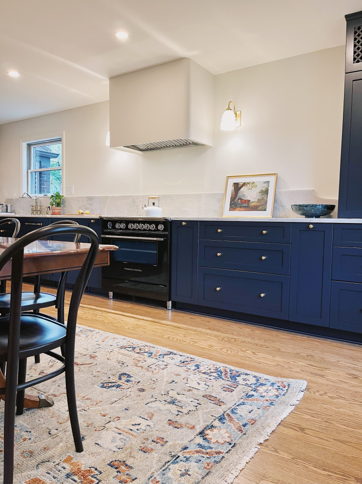 Eat-in kitchen - large transitional l-shaped medium tone wood floor and brown floor eat-in kitchen idea with an undermount sink, shaker cabinets, blue cabinets, quartzite countertops, stone slab backsplash, paneled appliances, no island and gray countertops