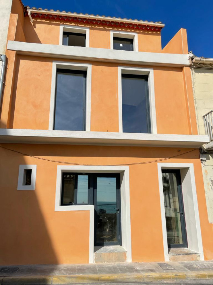 Mittelgroßes, Dreistöckiges Mediterranes Reihenhaus mit oranger Fassadenfarbe, Satteldach, Ziegeldach und braunem Dach in Montpellier
