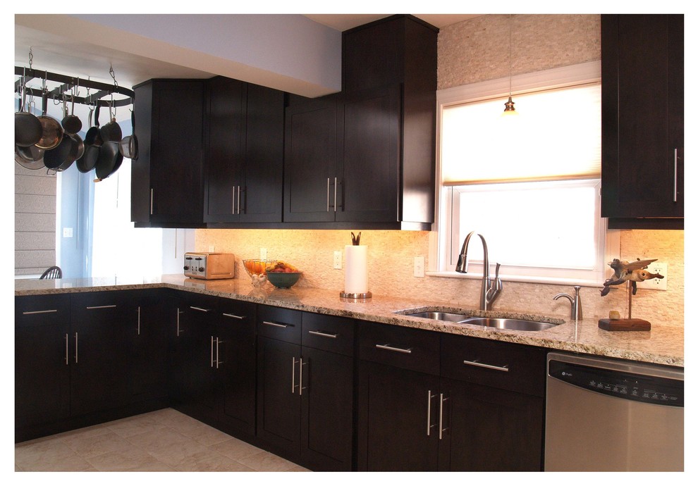 Mid-sized contemporary l-shaped eat-in kitchen in Baltimore with a double-bowl sink, shaker cabinets, dark wood cabinets, granite benchtops, stainless steel appliances, beige splashback, no island and stone tile splashback.