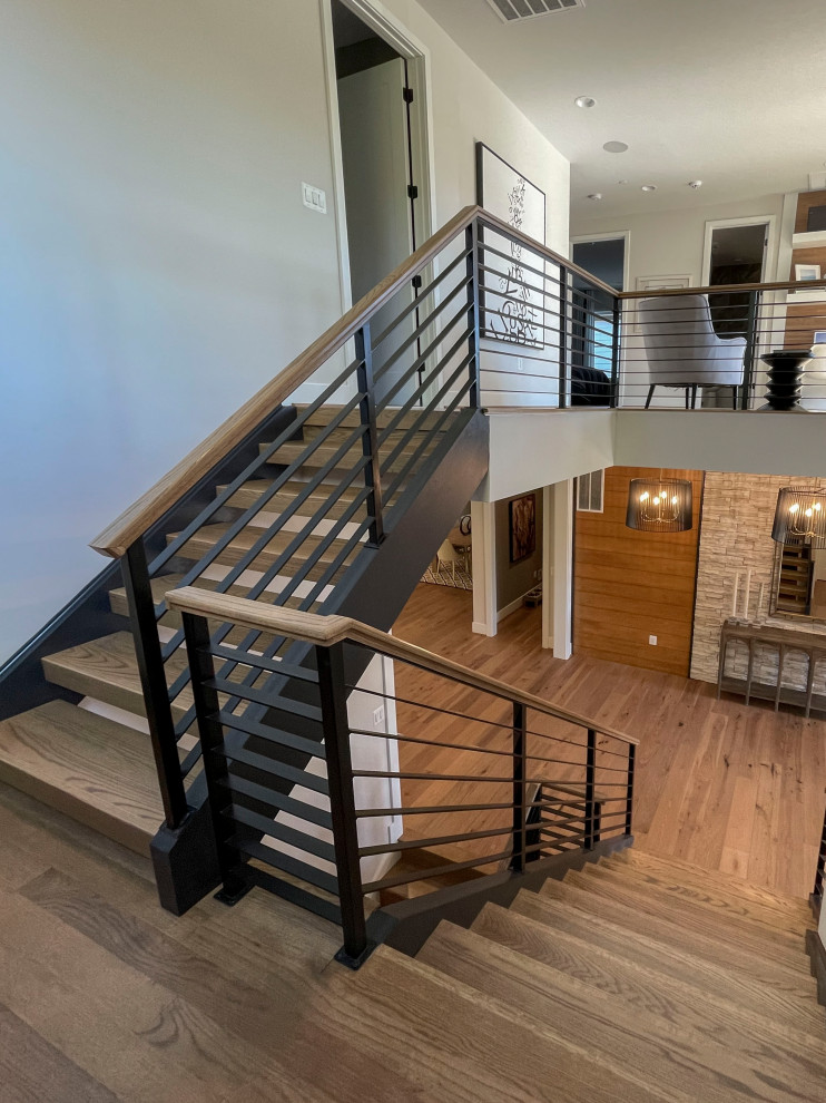 This is an example of a large contemporary wood straight mixed railing staircase in DC Metro with panelled walls.