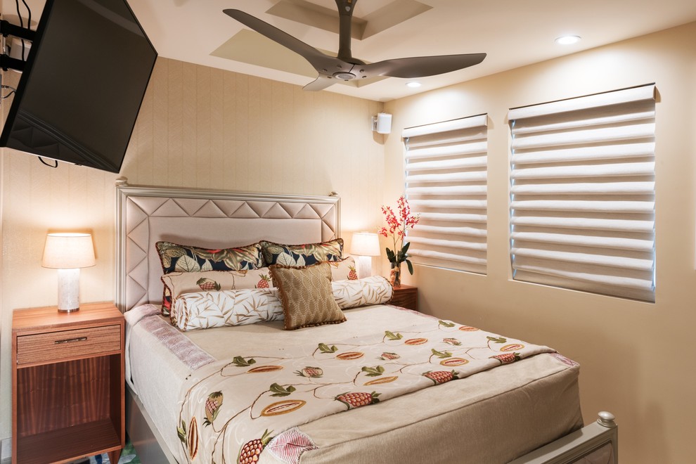 This is an example of a tropical guest bedroom in Hawaii with limestone floors and beige floor.