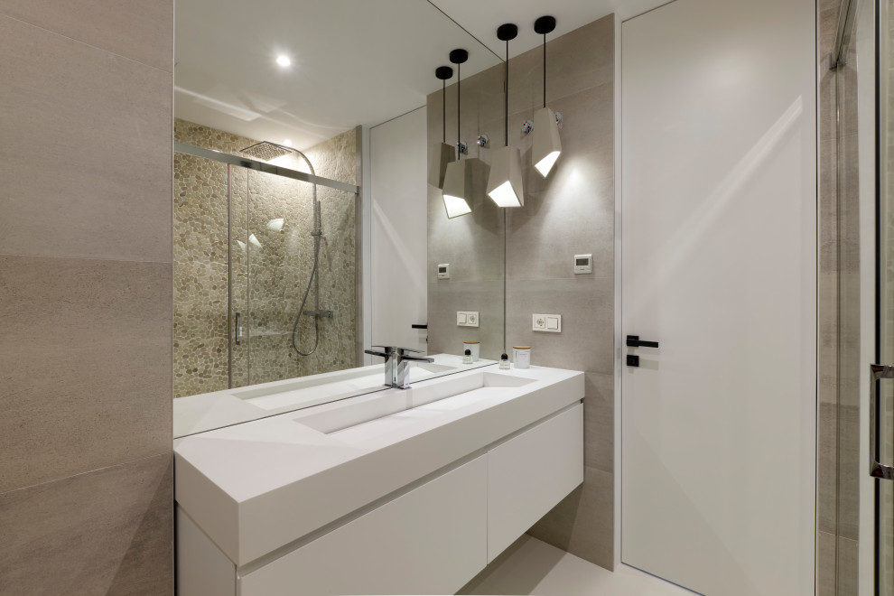 Design ideas for a medium sized contemporary ensuite bathroom in Malaga with freestanding cabinets, white cabinets, a built-in shower, grey tiles, engineered stone worktops, a sliding door, white worktops, a single sink and a floating vanity unit.