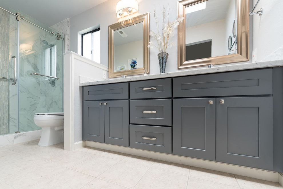 Example of a large transitional master white tile and marble tile travertine floor and beige floor alcove shower design with shaker cabinets, gray cabinets, a two-piece toilet, beige walls, an undermount sink, quartzite countertops and white countertops