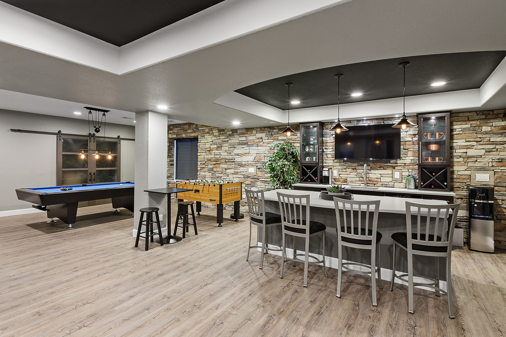 This is an example of a mid-sized contemporary fully buried basement in Denver with grey walls, light hardwood floors, no fireplace and beige floor.