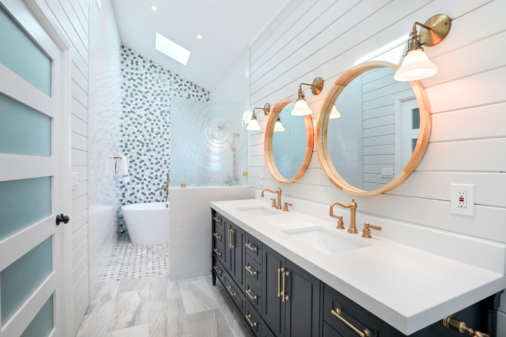 Inspiration för mellanstora maritima vitt en-suite badrum, med blå skåp, ett fristående badkar, en kantlös dusch, vita väggar, ett undermonterad handfat, bänkskiva i kvarts, grått golv, med dusch som är öppen, luckor med infälld panel och flerfärgad kakel