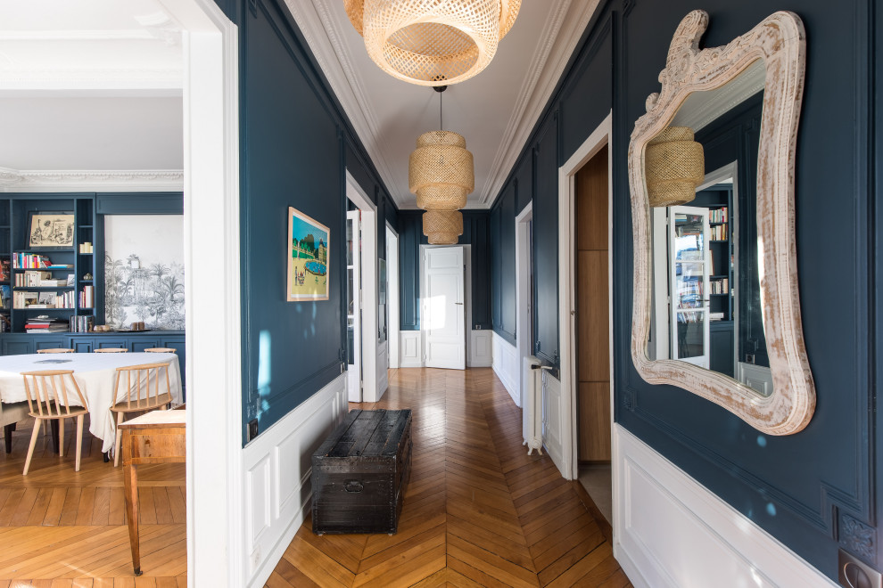 Design ideas for a large transitional foyer in Paris with blue walls, light hardwood floors, a double front door, a white front door, beige floor and decorative wall panelling.