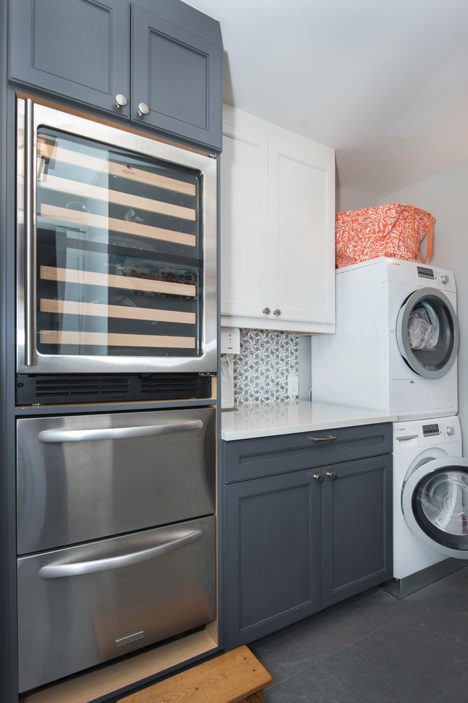 Inspiration for a mid-sized modern single-wall utility room in New York with shaker cabinets, white cabinets, solid surface benchtops, white walls, porcelain floors, a stacked washer and dryer and white benchtop.