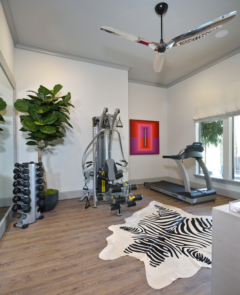 Photo of a mid-sized eclectic home weight room in Houston with grey walls, medium hardwood floors and brown floor.