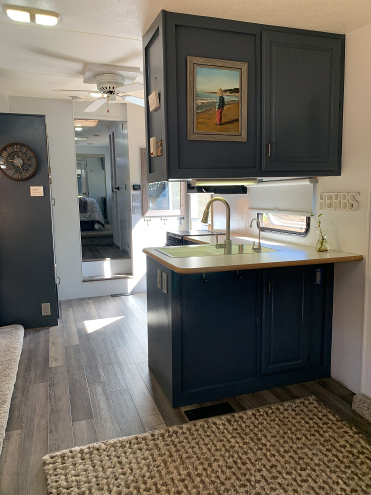 サクラメントにある高級な小さなエクレクティックスタイルのおしゃれなキッチン (青いキャビネット、ラミネートカウンター、グレーのキッチンパネル、黒い調理設備、ラミネートの床、アイランドなし、グレーの床、ベージュのキッチンカウンター) の写真