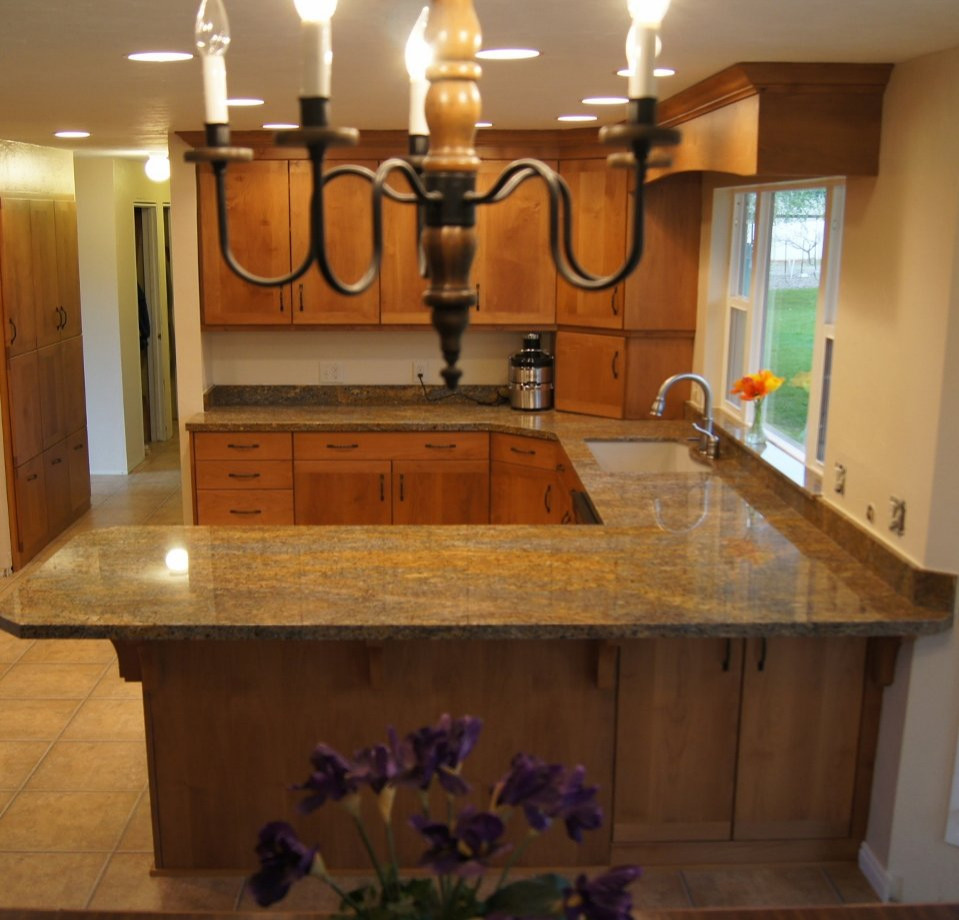 Photo of a country kitchen in London with marble benchtops and orange benchtop.