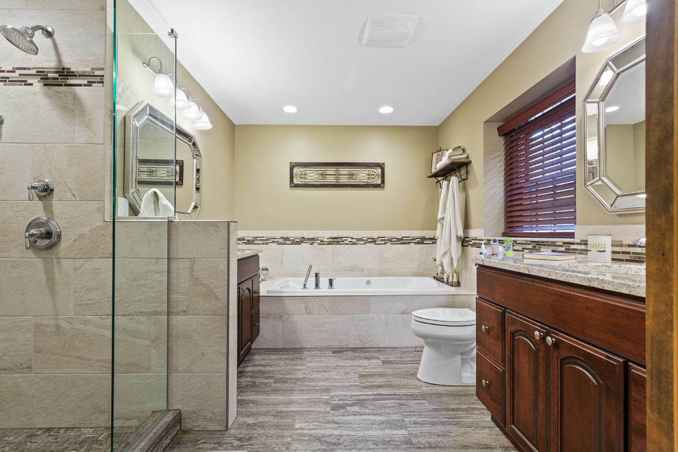 Large traditional master bathroom in Chicago with shaker cabinets, brown cabinets, a drop-in tub, an alcove shower, white tile, ceramic tile, an integrated sink, marble benchtops, a hinged shower door and beige benchtops.