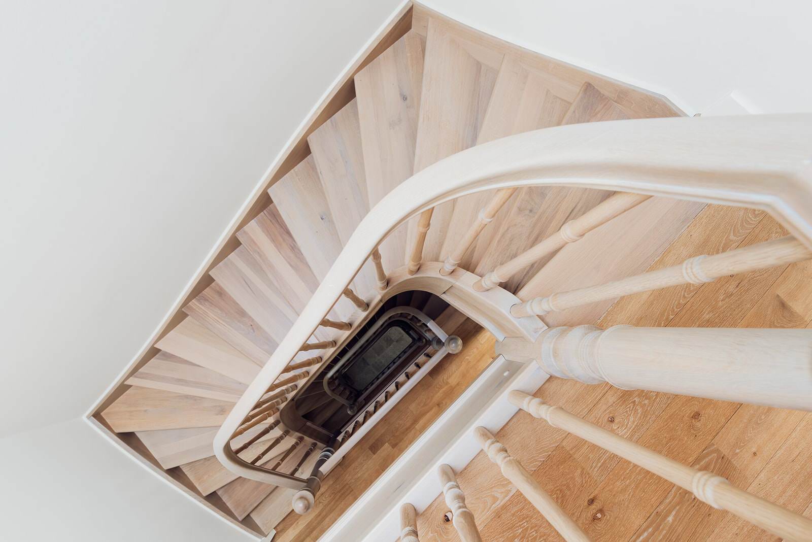 Классическая лестница из дуба с изогнутыми перилами