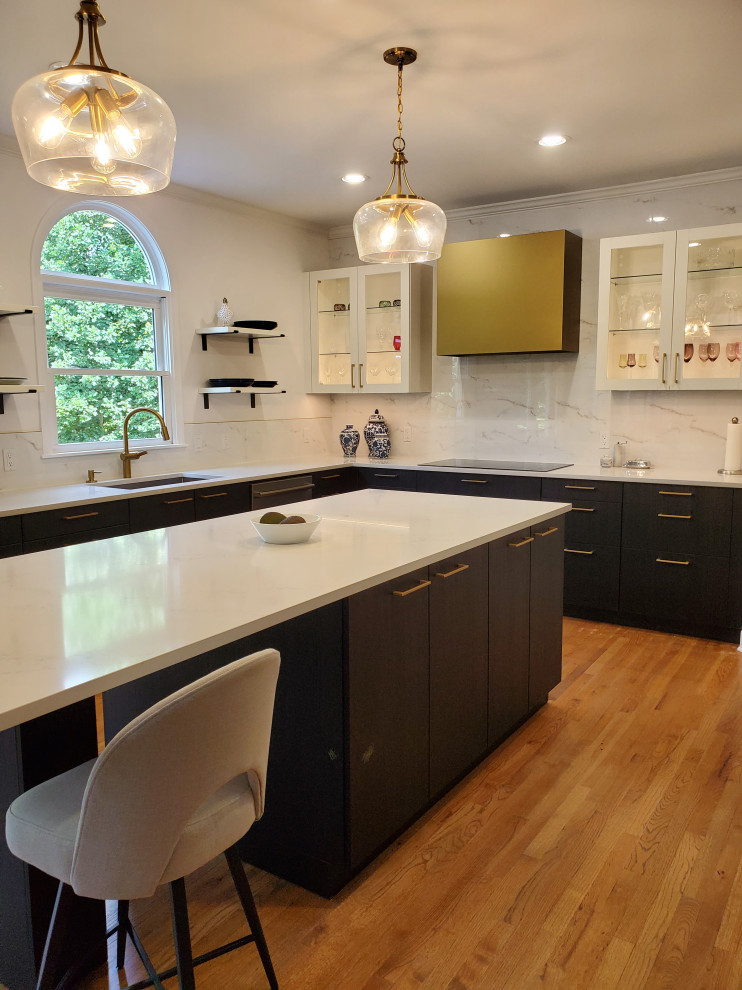Lantlig inredning av ett mellanstort vit vitt kök, med en enkel diskho, luckor med glaspanel, svarta skåp, bänkskiva i kvarts, vitt stänkskydd, stänkskydd i stenkakel, rostfria vitvaror, ljust trägolv, en köksö och flerfärgat golv