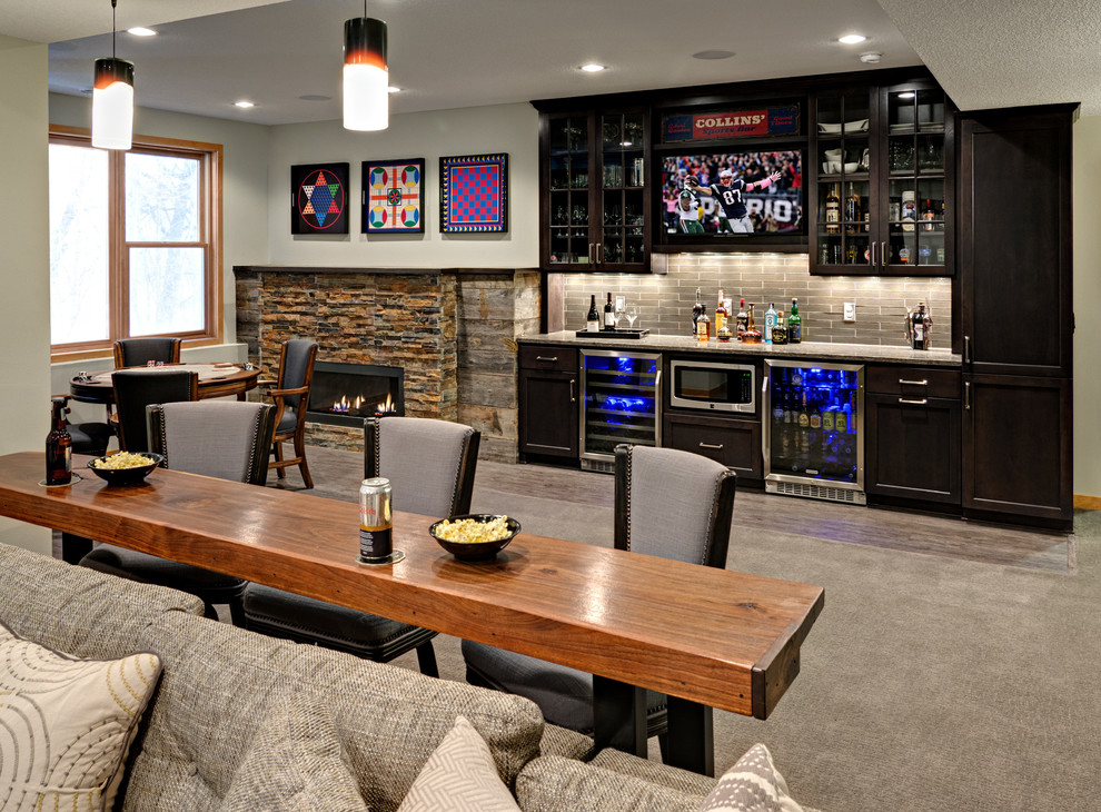 Inspiration for a mid-sized transitional walk-out carpeted basement remodel in Minneapolis with gray walls, a standard fireplace and a stone fireplace