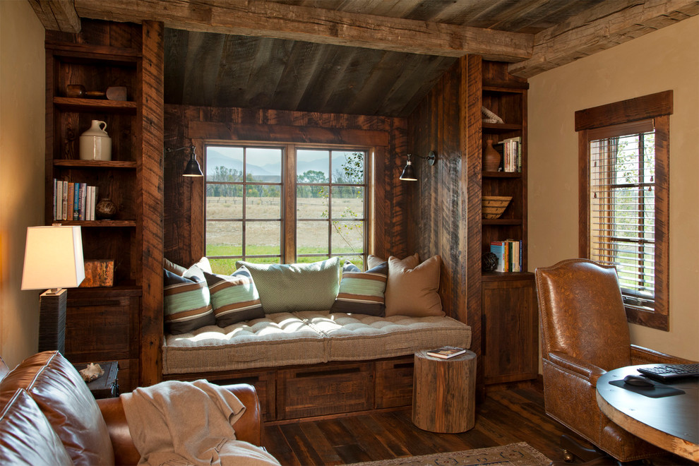 Mid-sized country home office in Other with beige walls, dark hardwood floors and a library.