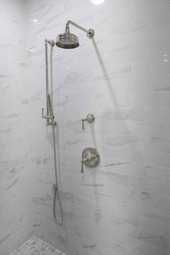 Large transitional master white tile and porcelain tile porcelain tile and white floor freestanding bathtub photo with shaker cabinets, white cabinets, a two-piece toilet, beige walls, an undermount sink, marble countertops, a hinged shower door and white countertops
