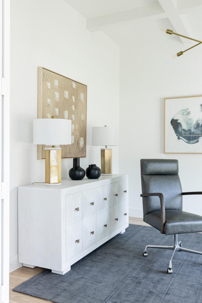 Geräumiges Maritimes Arbeitszimmer mit Arbeitsplatz, weißer Wandfarbe, hellem Holzboden, freistehendem Schreibtisch und braunem Boden in Dallas